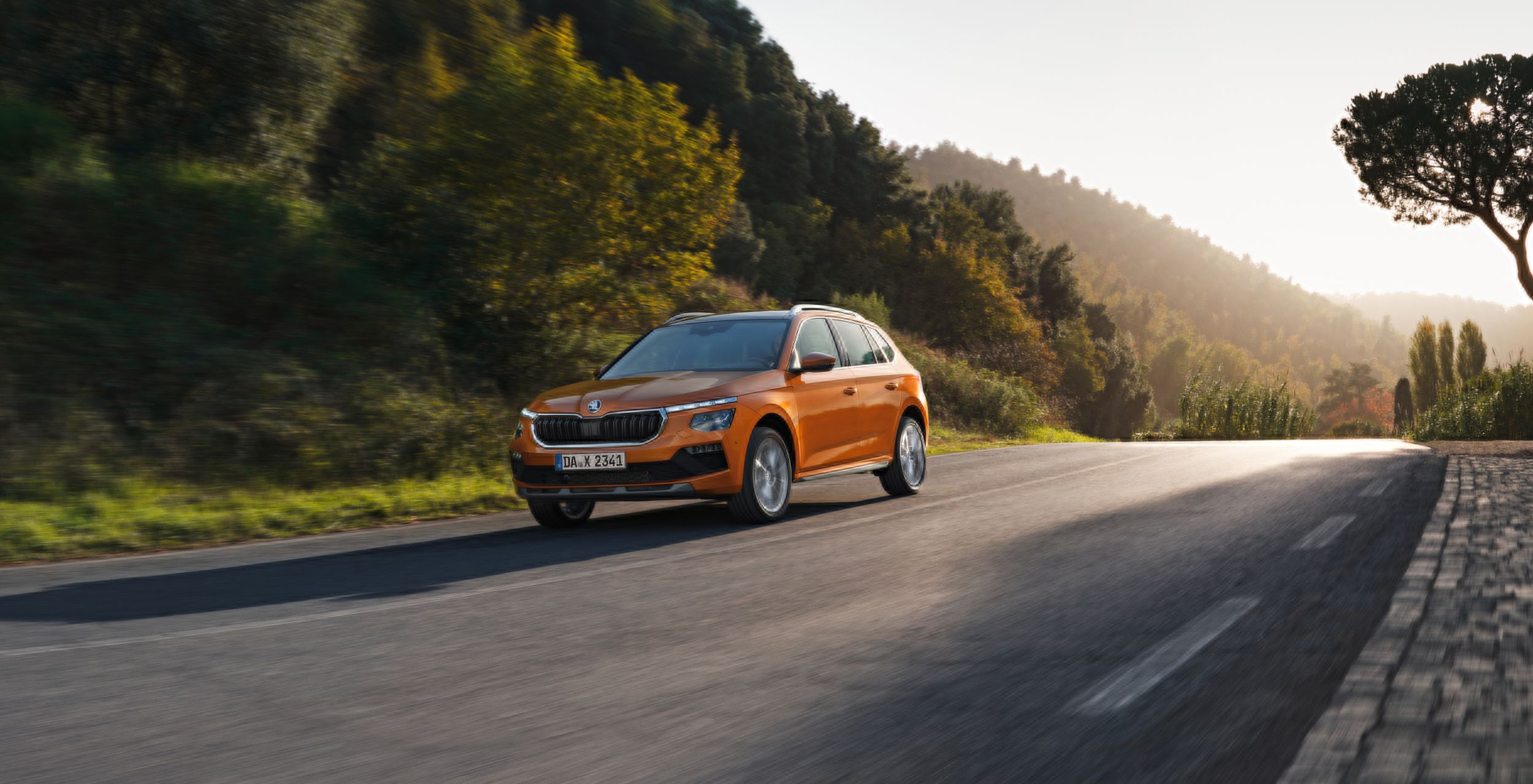 Zu sehen ist ein orangefarbener Škoda Kamiq.