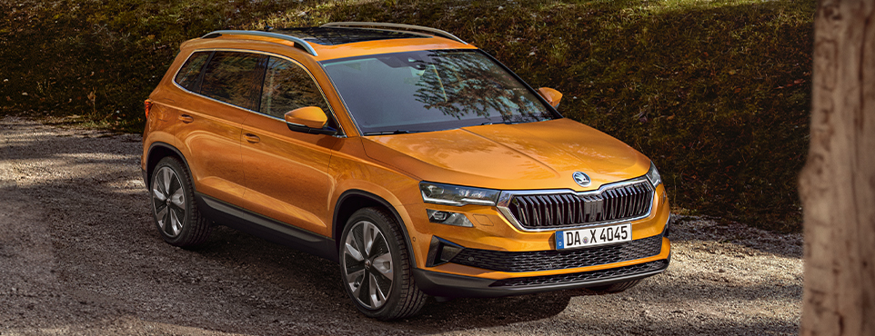 Zu sehen ist ein orangefarbener Škoda Karoq.